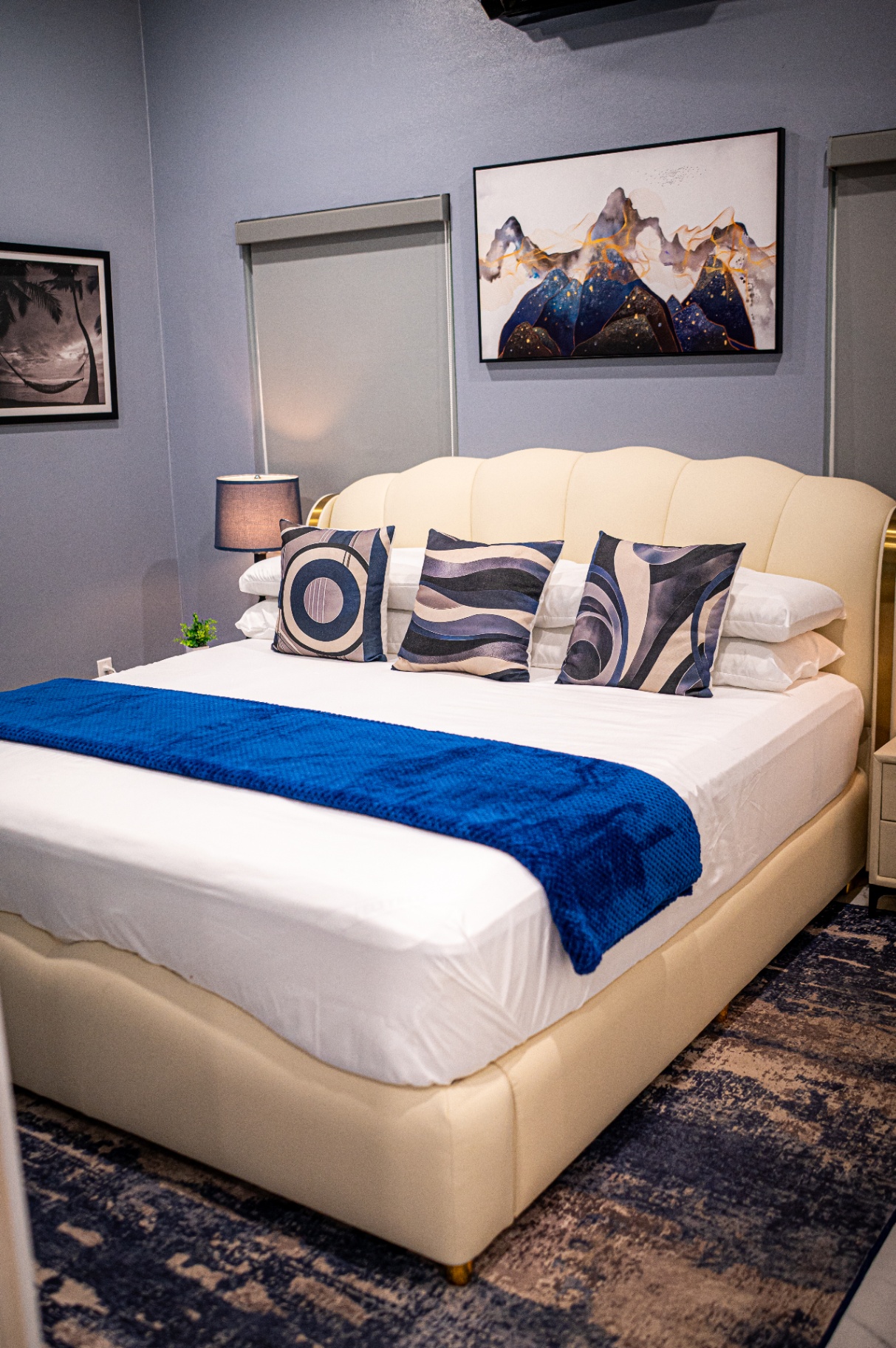 Apartment 1 king bed with blue throw and framed art