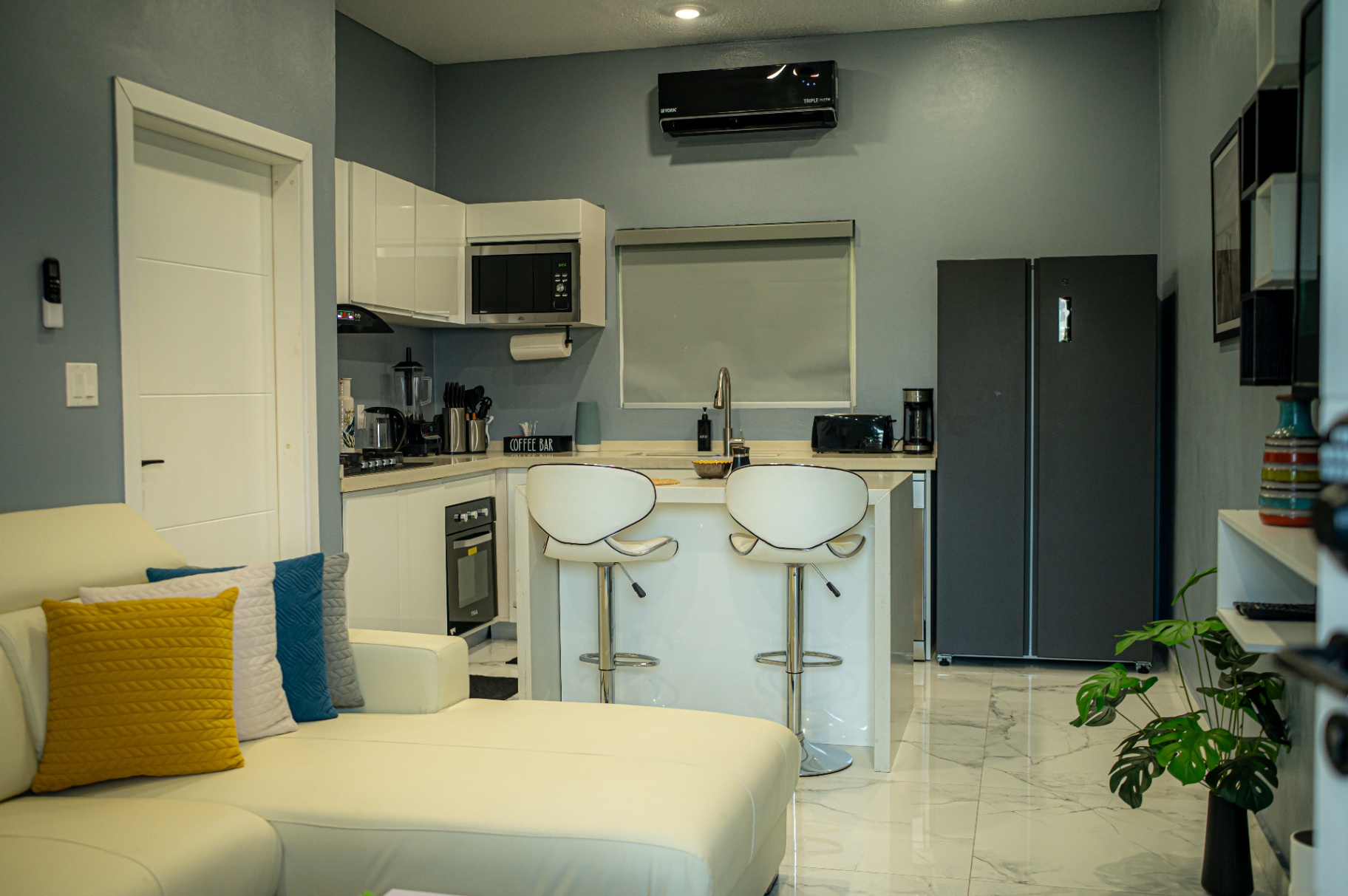 Apartment 2 kitchen with white cabinetry and breakfast bar